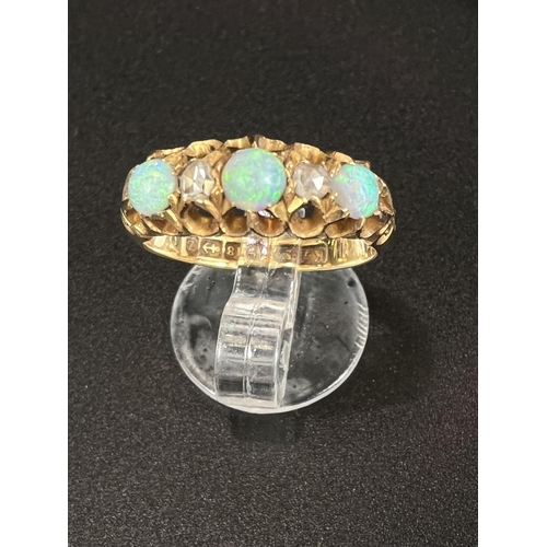 684 - An 18 carat hallmarked gold ring with 3 opals and 2 diamonds in split shank gypsy style setting, 4.9... 