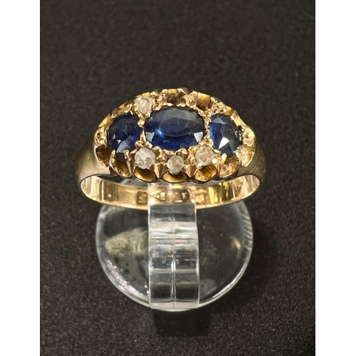 685 - An 18 carat hallmarked gold dress ring with 3 sapphires and diamond chips in split shank setting (2 ... 