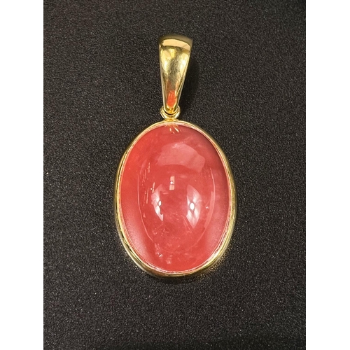 694 - A pendant set cabochon cut pink stone, the yellow metal surround, stamped '750'