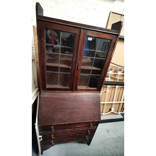 954 - An oak bureau bookcase with leaded glass top and an oak panel with turned supports