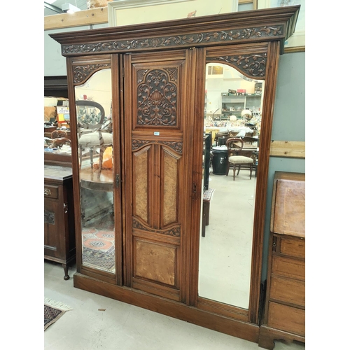 972 - A late 19th / early 20th century carved walnut wardrobe with 2 mirror doors and central carved door,... 