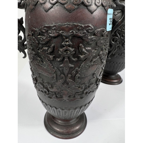 398 - A pair of Japanese bronze vases with relief decoration of dragons, dragon handles etc, ribbed rims, ... 