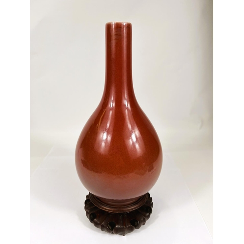 402 - A Chinese oxblood glazed bottle vase, with seal mark to base, hard wood stand, height 32cm