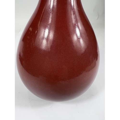 402 - A Chinese oxblood glazed bottle vase, with seal mark to base, hard wood stand, height 32cm