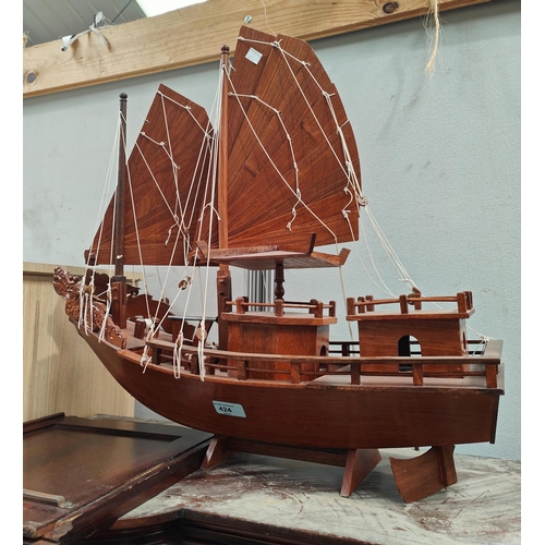 424 - A model of a 2 masted Chinese junk in carved hardwood. length 60cm