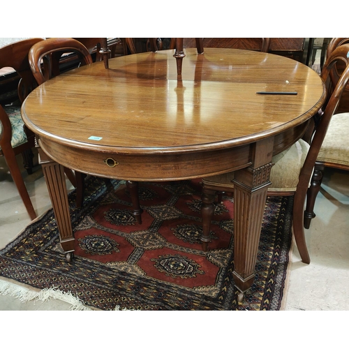 831 - A late 19th/early 20th century mahogany dining table with oval wind out top on square tapering reede... 