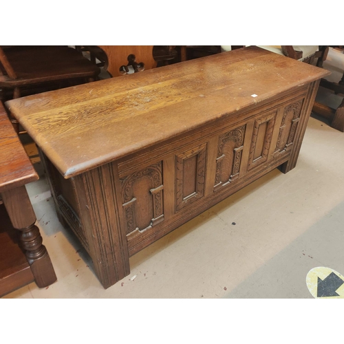 836 - An oak reproduction blanket box with carved panels