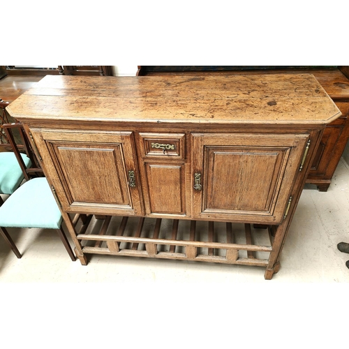 988 - An oak country made side cabinet with double doors, panelled decoration, small central spice drawer ... 