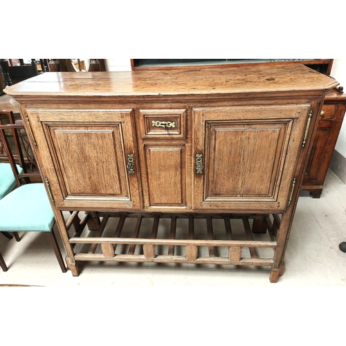 988 - An oak country made side cabinet with double doors, panelled decoration, small central spice drawer ... 