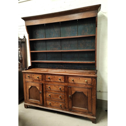 989 - An large 18th century oak country made Welsh dresser with four central drawers, two cupboards with d... 