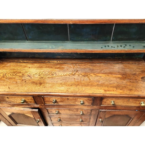 989 - An large 18th century oak country made Welsh dresser with four central drawers, two cupboards with d... 