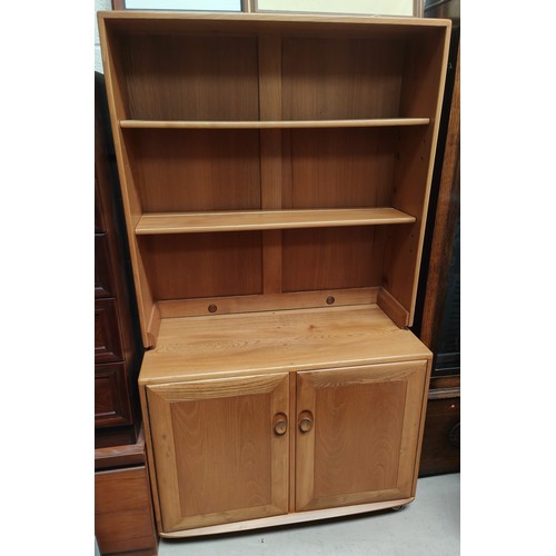 1006 - An Ercol lightwood wall unit with two height bookcase above and double cupboard bellow