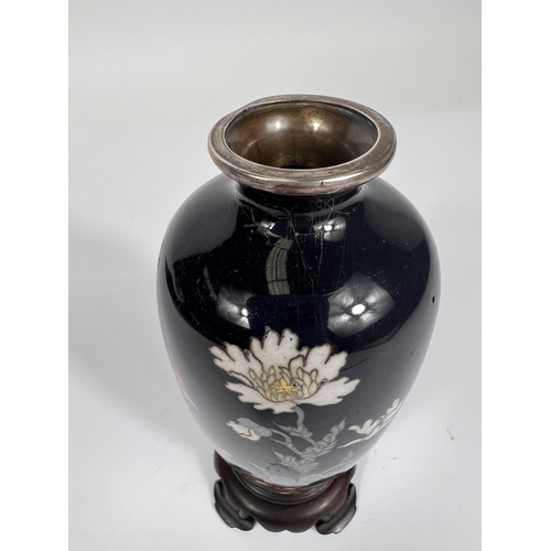 384A - A Chinese cloisonne with deep blue ground floral decoration silvered rim vase attached to hardwood s... 