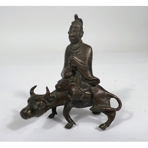 393 - A Chinese Ching Dynasty bronze scroll weight in the form of scholar sat on ox height 8cm