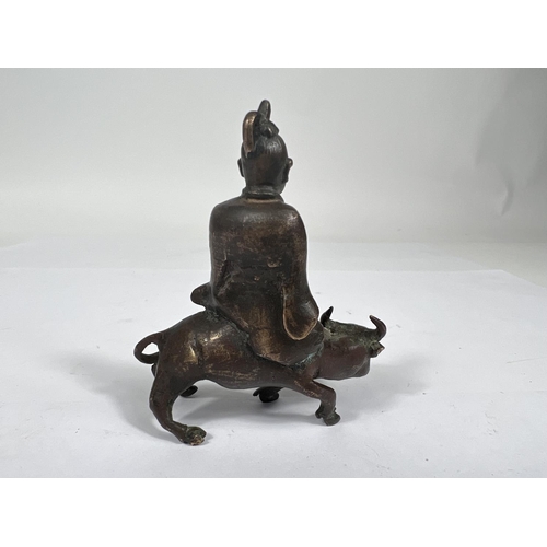 393 - A Chinese Ching Dynasty bronze scroll weight in the form of scholar sat on ox height 8cm