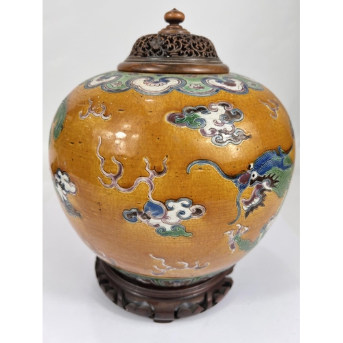 396 - A Chinese ginger jar shaped vase with an exotic bird and dragon in polychrome against a mustard glaz... 