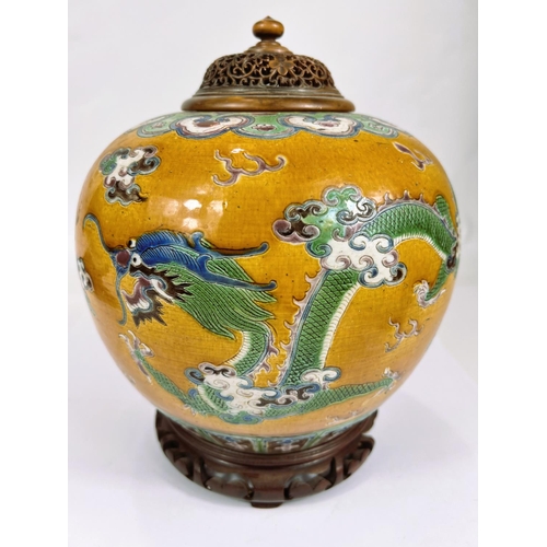 396 - A Chinese ginger jar shaped vase with an exotic bird and dragon in polychrome against a mustard glaz... 