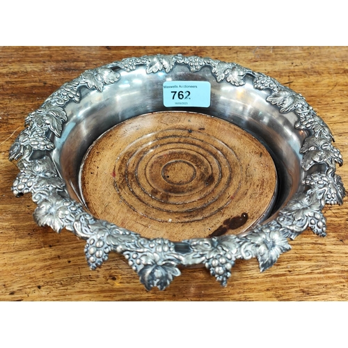 762 - A silver plated Magnum sized wine coaster with scrolling wine decoration