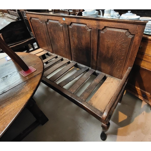 894 - An 18th century Country made oak settle with 3 arched and fielded panels to the back, slatted seat a... 