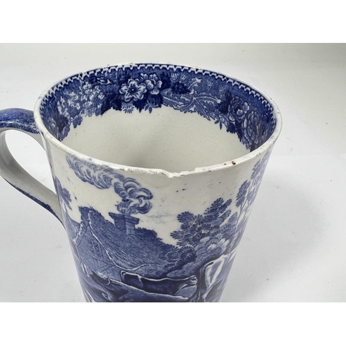 582 - A 19th century Adame blue and white mug decorated with cattle grazing (underglaze chip to rim)