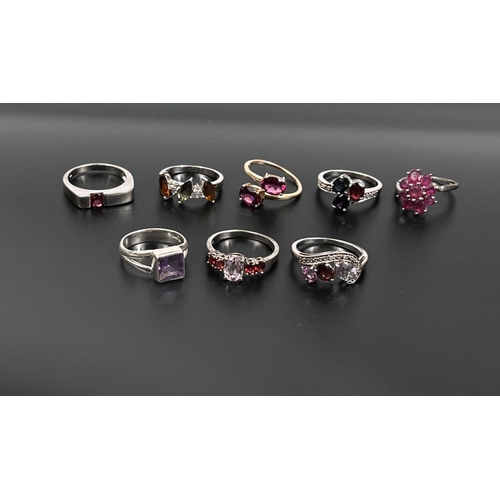 634 - Eight silver rings in a variety of designs, set assorted red/pink stones, 27.2gm