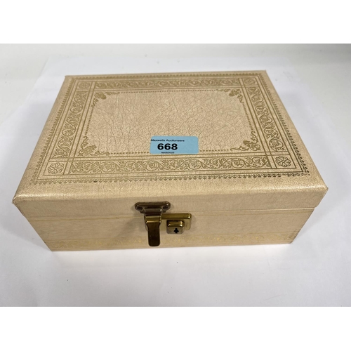 668 - A cantilevered jewellery box with costume jewellery and watches