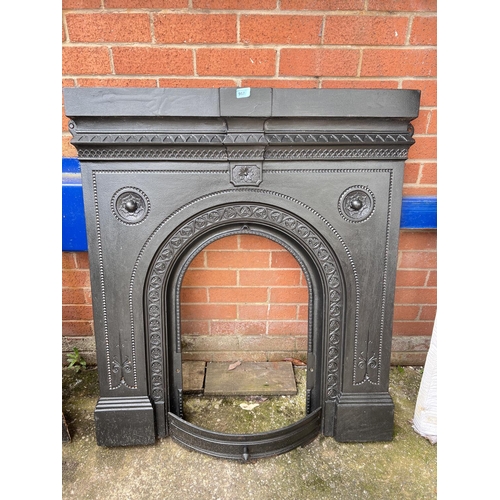 957 - A cast iron fire surround with traditional decoration 106 x 97cm, opening 65 x 40cm