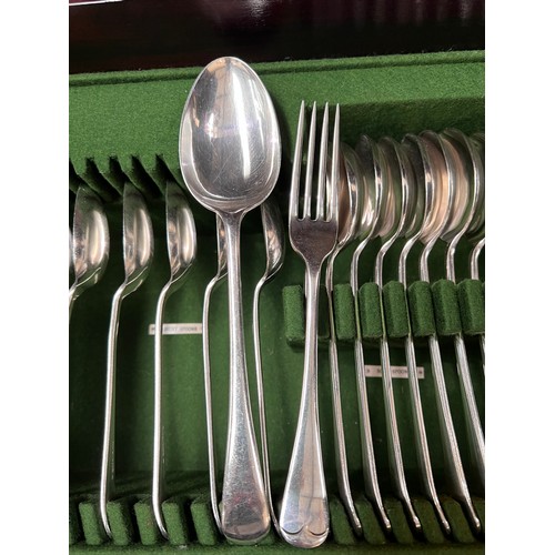 739 - A 12 setting canteen of silver plated cutlery housed in demi-lune mahogany table / cabinet