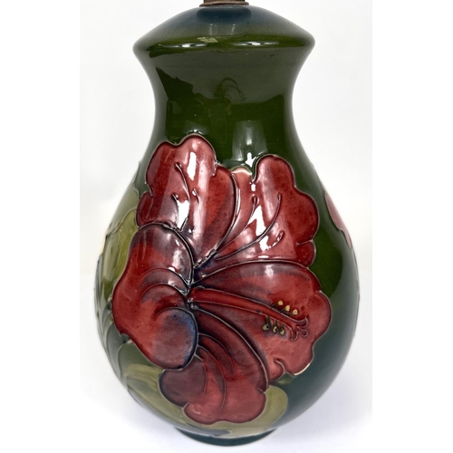 596 - A Moorcroft green ground table lamp, red and green Hibiscus flower decoration, height 19cm