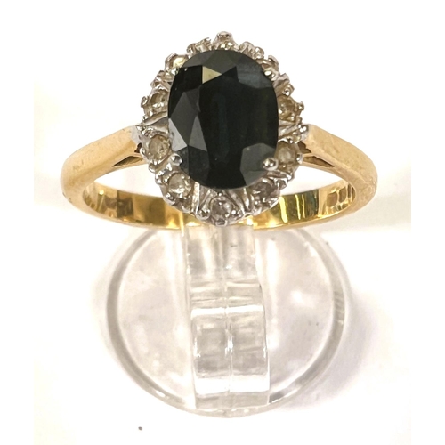 614 - An 18 carat hallmarked gold ring set oval sapphire surrounded by 12 diamonds, size M, 4gm