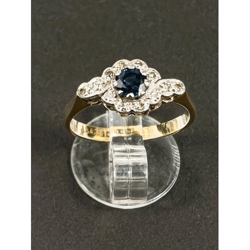 645 - An 18ct hallmarked gold ring with central sapphire and small diamonds in crossover form