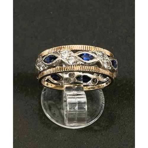 647 - A two tone yellow and white metal dress ring set with blue and white sapphires, 3.6gms, size K