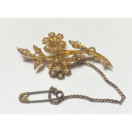 670 - A seed pearl set brooch in the form of flowers and leaves, stamped '18ct', 4.88gm