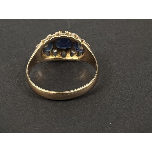 683 - An 18 carat hallmarked gold dress ring with 3 sapphires and diamond chips in split shank settin... 