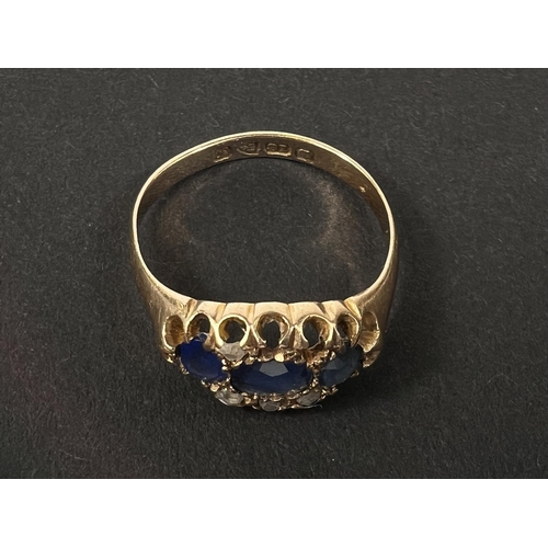 683 - An 18 carat hallmarked gold dress ring with 3 sapphires and diamond chips in split shank settin... 