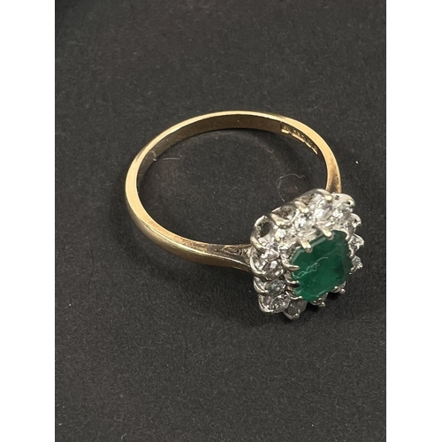 686 - An 18 carat hallmarked gold dress ring set square cushion cut emerald surrounded by 14 diamonds... 