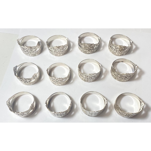 695 - A set of 12 silver plated napkin rings with pierced and etched decoration, with numbered settings fr... 