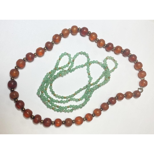 710 - An amber bead necklace, 33gm; a jade coloured stone necklace