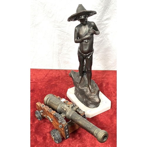 40A - A reproduction miniature cannon, length 34cm; a spelter figure:  boy hugging a fish (a.f.), hei... 