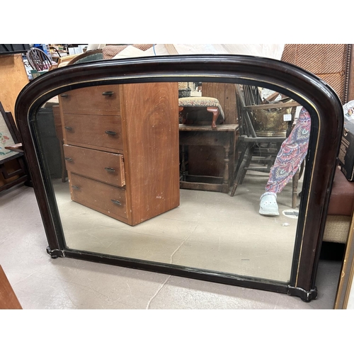 977 - A reproduction overmantle mirror in ebonised frame