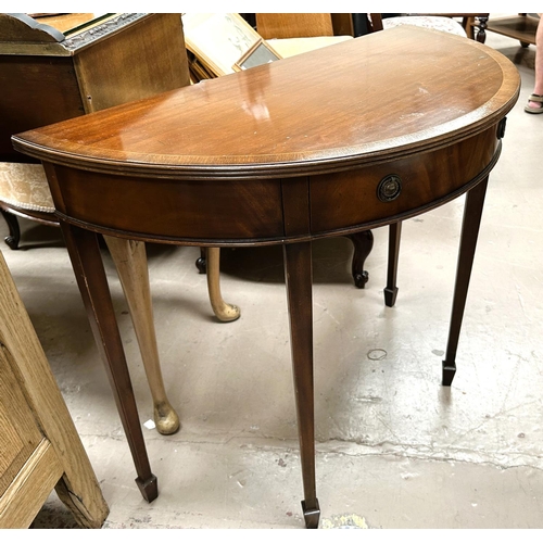 989 - A mahogany reproduction crossbanded demi-lune table with single drawer bearing label for Thomas Glen... 