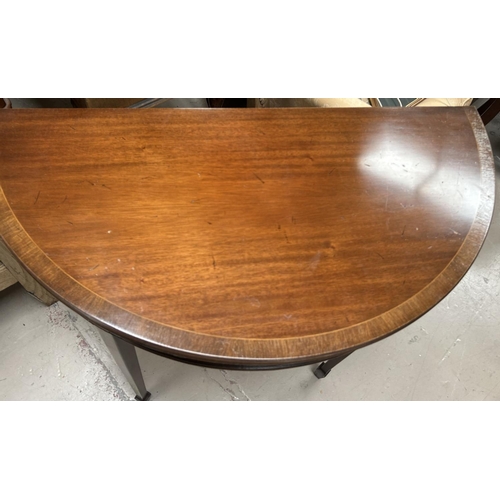 989 - A mahogany reproduction crossbanded demi-lune table with single drawer bearing label for Thomas Glen... 