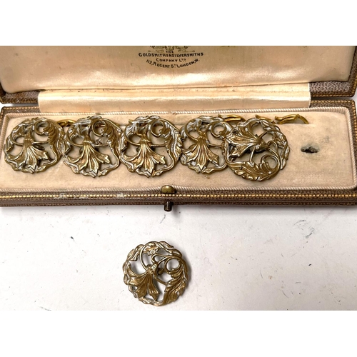 698C - An Art Nouveau set of gilt cased buttons, floral pierced decoration, in fitted cream lined presentat... 