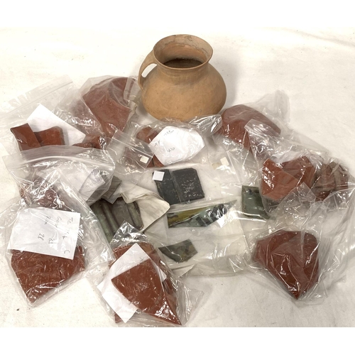 27 - A collection of ancient terracotta vessel shards and several part pieces of early stained glass.