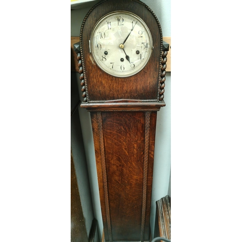 31A - A 1930's oak granddaughter clock with arch top and barley twist side columns and chiming movement, h... 