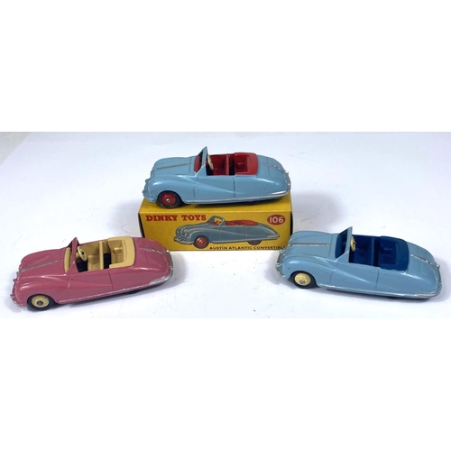 358 - DINKY TOYS: Three 106 Austin Atlantic Convertibles, pink with beige interior and hubcaps, two blue o... 