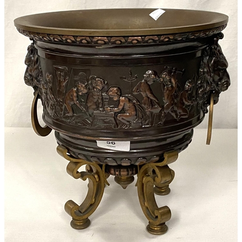 56 - A heavy brass jardiniere with lion mask and ring handles and central relief panel decorated with che... 