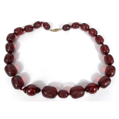 702A - A string of cherry beads with spiral fluted decoration, 50g.