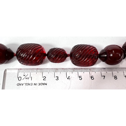 702A - A string of cherry beads with spiral fluted decoration, 50g.