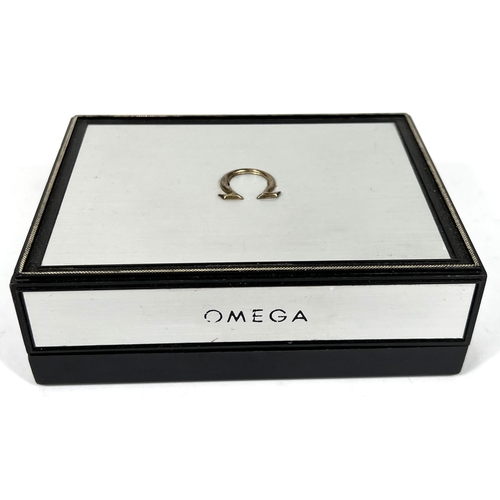 703 - An Omega, brushed aluminium finish watch box. 13 x 10cm